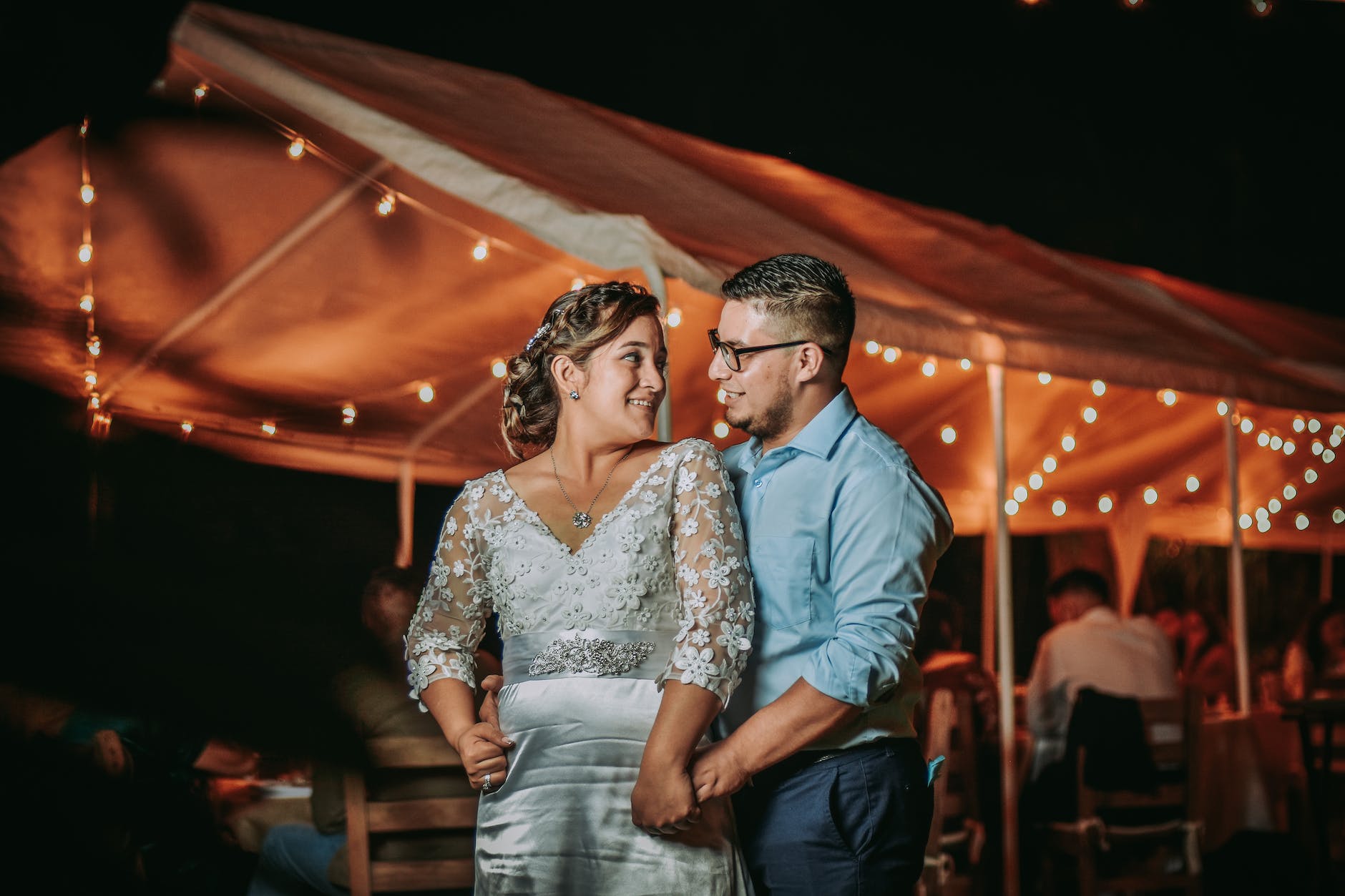 man in blue shirt hugging woman in white dress